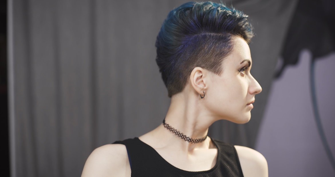 mulher branca com cabelo azul usando o corte mid fade